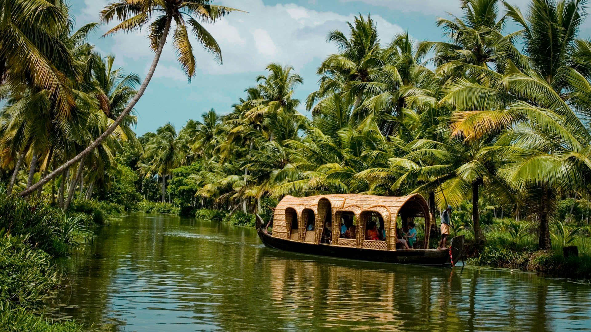 Kerala backwaters with houseboat and palm trees